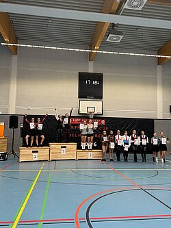 Siegerehrung beim North Star Cup in Delmenhorst: Tanzpaare stehen mit Urkunden auf und neben dem Siegerpodest