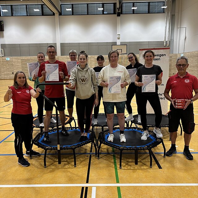 Gruppenfoto der neuen WJ Basic Instruktorinnen und Instruktoren mit Urkunden in der Sporthalle